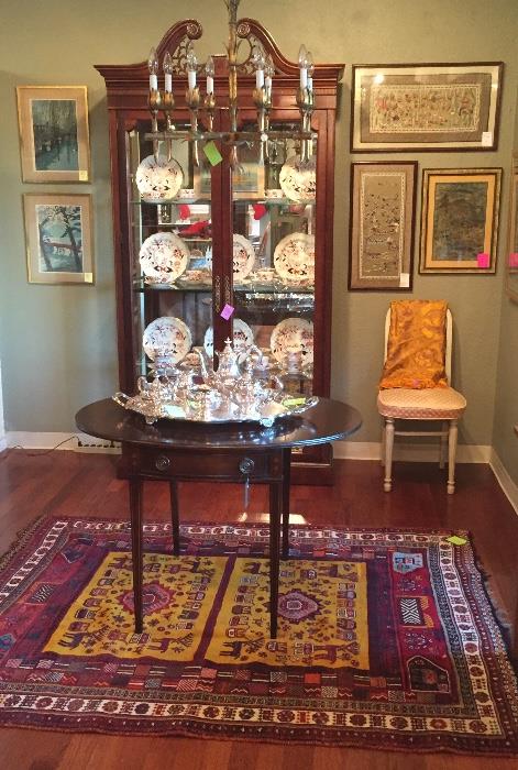 Mahogany curio, faux bamboo metal chandelier from 1970, vintage mahogany drop leaf table, mid-century chair, embroidered silk art, fine china, and woven rug.