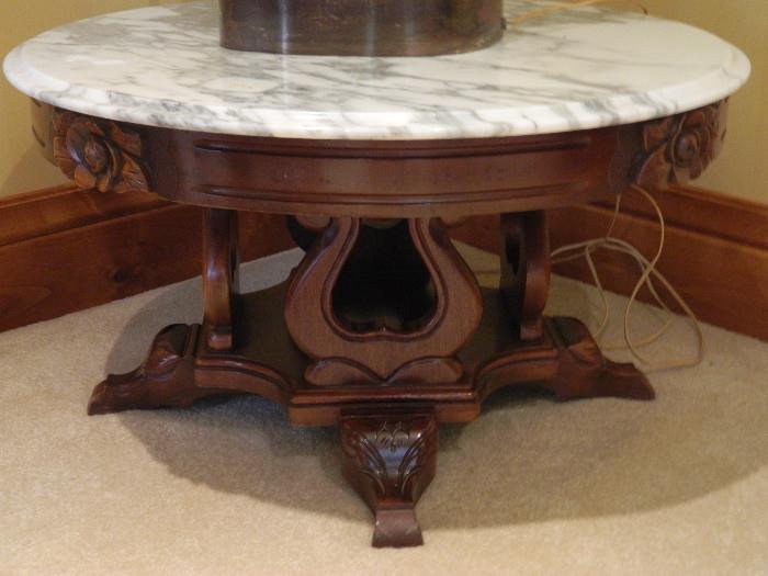 Low ornate table with carved legs and marble top 