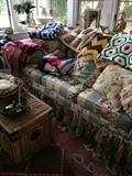 Immaculate upholstered sofa with throw pillows, collection of crochet blankets