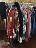 Racks of clothing: jackets, scarves, tweed, blouses, wool, cashmere, silk, wraps, dresses, embroidered and beaded