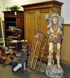Various Antiques & vintage items. From England, USA, among others. Gossip bench, raggedy Ann rocking toy, Iron and brass candle sticks, statues, wicker, plants, bird cage, underwood typewriter, wine rack, and more antique book case, antique sled, Indian statue with coyote, antique rocking horse, antique high chair and much more