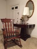 Empire center table, crystal lamp, oval mirror and mahogany rocker.