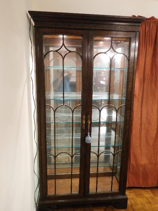 There are two of these mirrored, lighted china cabinets with grooved glass shelves.