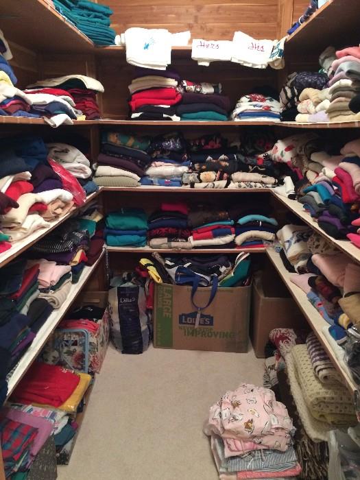 A closet full of men's and women's sweaters, golf shirts, turtlenecks, pajamas, totes, sweaters, scrubs, and socks, much of it brand new, much of it brand name