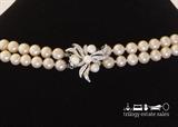 Closure of unmarked 26" double strand of faux pearls with box clasp decorated with sliver flower, rhinestones and three faux pearls. Warm ivory color. Matching bracelet available.