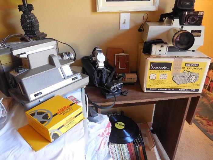 Slide projectors and vintage Kodak Instamatic camera. LP record albums