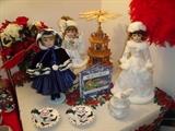 Wood revolving pyramid in background.  Dolls ready for winter