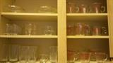 Glasses to the left; 13 Pyrex measuring cups to the right
