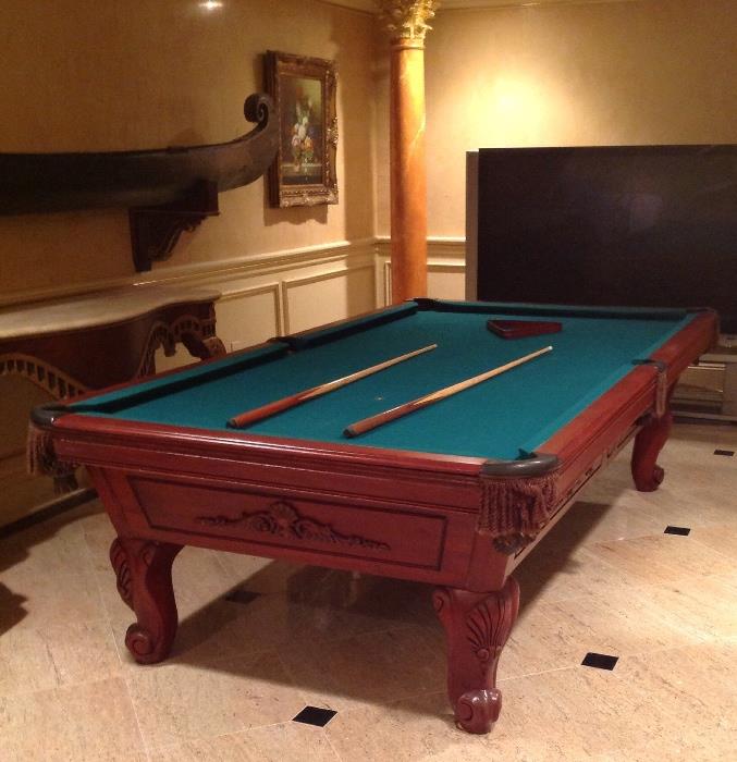 Traditional style mahogany pool table and antique Asian canoe outfitted as a bar