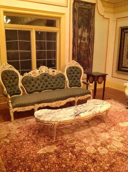 Carved painted sofa and marble top coffee table,  one of a pair of scenic tapestries painted on fabric, one of a pair of end stands with ormolu