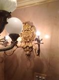 A pair of antique bronze lion head sconces