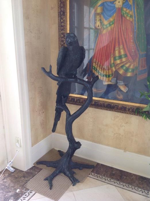 Bronze statue of a parrot on a branch