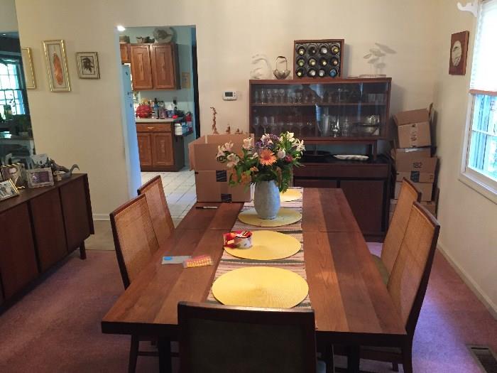 Mid-Century Modern walnut and laminate extension dining table, six chairs (two arm and four sides), a two-part china cabinet and a sideboard by Dillingham.			
