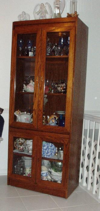 Tall 2 door curio filled with glassware, cup and saucer collection, angel figurines and more