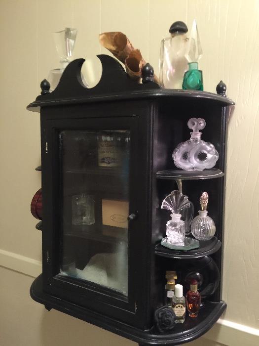 deco wall cabinet with perfume bottles, etc