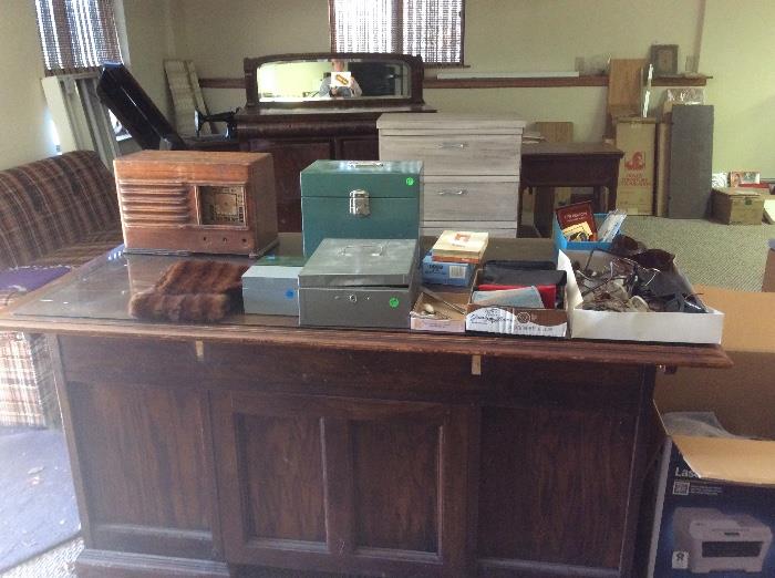 Backside of wood desk, old radio shell, metal boxes
