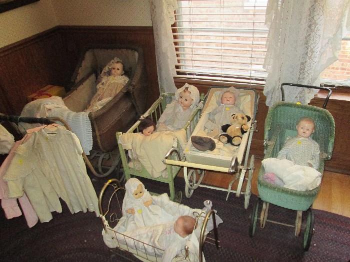 A variety of baby and doll carriages and beds.