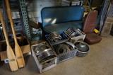 Several sets of old Chevy hubcaps.  More car parts.  Several oars and a rudder for a sailing boat.