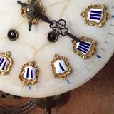 Roman numeral marble dial adorned in cloisonne embellishments