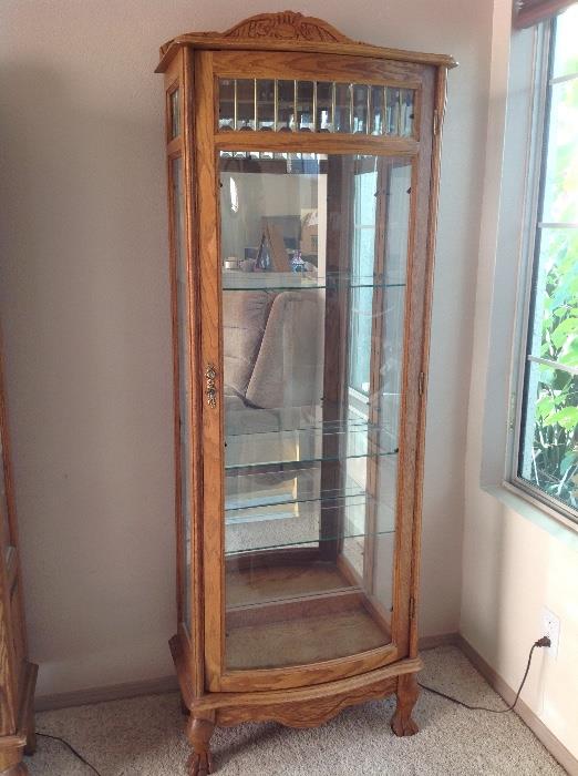 Oak curio cabinet with glass shelves and light