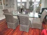 Glass pedestal table and six skirted chairs