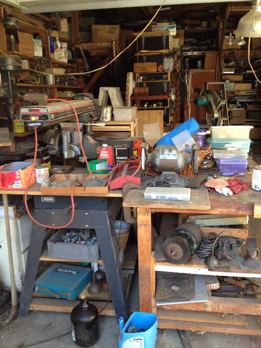 Sander, workbench, mitasaw, drill, shop lights, tools, shear blades, power cords, ladder, vintage tools, oil can, fan, wood, scrap metal, nails, screwdriver set, antique levels, antique stanley planes, electric drill, hacksaw, socket wrench, allen wrench, Combination Square, utility knife, Crosscut Saw, Wood glue, plumber's putty, dust mask, voltage tester, wheelbarrow, shovel, rake, step ladder, polisher