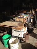Sander, workbench, mitasaw, drill, shop lights, tools, shear blades, power cords, ladder, vintage tools, oil can, fan, wood, scrap metal, nails, screwdriver set, antique levels, antique stanley planes, electric drill, hacksaw, socket wrench, allen wrench, Combination Square, utility knife, Crosscut Saw, Wood glue, plumber's putty, dust mask, voltage tester, wheelbarrow, shovel, rake, step ladder, dolly