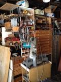 Sander, workbench, mitasaw, drill, shop lights, tools, shear blades, power cords, ladder, vintage tools, oil can, fan, wood, scrap metal, nails, screwdriver set, antique levels, antique stanley planes, electric drill, hacksaw, socket wrench, allen wrench, Combination Square, utility knife, Crosscut Saw, Wood glue, plumber's putty, dust mask, voltage tester, wheelbarrow, shovel, rake, step ladder, antique metal file cabinets, antique tool kits