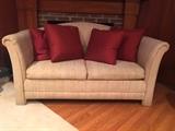Cream-colored sleeper-sofa loveseat with red silk pillows