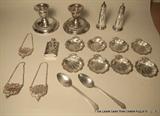 Assorted sterling silver table items, including nut dishes, liquor tags, salt & pepper shakers, candlesticks and more.