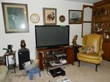 TV, TV Stand, small table, chair, speakers, clock, pictures