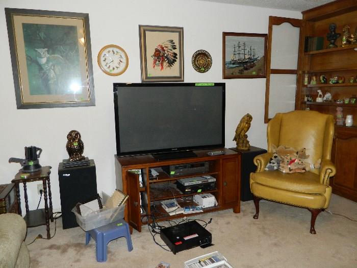 TV, TV Stand, small table, chair, speakers, clock, pictures