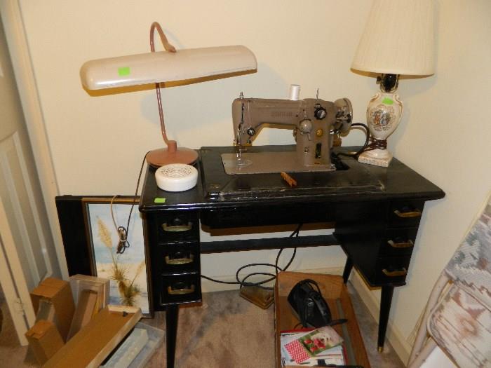 Vintage lamp, sewing machine in cabinet, various other items in bedroom