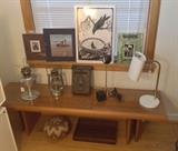 Mod 5 ft. teak coffee table, Alladin #23 lamp, Feuer Hand 275 Baby lantern, copper mail box, Lightolier Lytegem telescoping desk lamp, goose neck white desk lamp, serigraph of crow by R. Kirstem. Under table:  African basket with lid, rosewood desk tray
