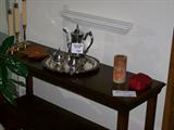 Sofa table displaying silverplated tea set and candles