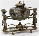 Lot#255, INDIAN BRASS TEA KETTLE ON FIGURAL STAND, H 12" TO THE HANDLE, L 10"