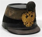 Lot#220, AUSTRIAN MILITARY SHAKO, ZIMBLER WEIN VII, 19TH C.,,high black felt over board crown with gilt embroidery at the top with woven wire pom-pom above gilt Austrian double headed eagle plate. Woven wire on short bill.