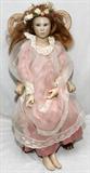 LOT#81  BRIGETTA DUVAL WAX DOLL, 'VIRGINIA', C1989, L 27", having a wax head, arms and feet, 27" L; fixed blue eyes, cloth body, long blonde wig, pink satin dress with a lace over slip, stitched collar and edges. Flower Tierra. Sitting in a miniature painted arm chair.