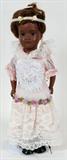 LOT#88  ARMAND MARSEILLE, BISQUE HEAD  DOLL, AFRICAN AMERICAN, H 14 1/2", glass sleep eyes, brown wig glued to head, with silk head ban. Open mouth with teeth. White embroidered dress with lilac flowers. Black leather shoes. On metal stand. Jointed limbs, fixed head.