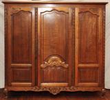 LOT#126  BELGIAN CARVED OAK WARDROBE, 20TH CENTURY, H 76", W 74", D 24", Beveled cornice above three paneled doors with floral and shell carvings, on whorl feet with acanthus carved knees. Two doors open to hanging space, center door to fitted area with shelves.