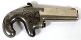 LOT#214  COLT FIRST MODEL .41 DERRINGER, #3946 PIVOTING BARREL BREECH, C1880, L 2 1/2" BBL, Manufactured from 1870 to 1890, this Colt First Model, .41cal. Rim fire Derringer, 2 1/2" nickel plated barrel with pivoting barrel breech; features half-moon front and hammer notch rear sights.  The top of the barrel is marked with the standard address/model marking: "COLT'S PT.F.A. MFG. Co. / HARTFORD CT. U.S.A." followed by "No1" flanked by Maltese crosses.  The serial number (3946) is marked on the underside of the barrel.  Having a barrel button release on the right side of the frame with the letter "G" ahead of the trigger.  The frame has light scroll engraving.  The spur trigger and hammer are checkered. The grip area is iron, with shallow checkering on the sides, deep, sharp checkering on the backstrap, and the matching serial number repeated on the butt. ANTIQUE: NO MODERN FIREARM PAPERWORK REQUIRED;