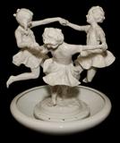 LOT#1214  HUTSCHENREUTHER PORCELAIN FIGURAL GROUP, H 10 1/4", Three girls playing ring-around-the-rosie, on a separate round base, Dia.9", stamped in green at the underside.