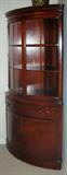 LOT#1228  MAHOGANY CORNER CABINET CIRCA 1940 H 71", W 44", China cabinet having curved front,  two upper doors, curved and inset with glass panes. Lower cabinets are mahogany panels. Center drawer. Cornice has fluted detail.