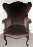 LOT#1254  GEORGIAN STYLE WINGBACK CHAIR CIRCA 1940, Mahogany legs, modified wing back, upholstered in brown velvet. Cabriole legs having shell carving on knees.
