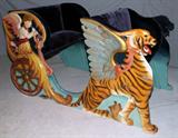 LOT#2055  DENTZEL EDGEWATER PARK CAROUSEL CHARIOT, H 45", W 45", L 78", Four seat. Ornately carved at both sides, depicting Gabriel with a trumpet, pulled by winged tiger striped griffins and the angel Gabriel riding a wheel blowing his horn. Two seats upholstered in plush.  Two original paintings at the back of the seats. Highly unusual for two "romance" sides.
