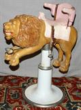 LOT#2052  BARBER SHOP LION FROM J.L. HUDSON CO., H 42", L 41", Child’s seat mounted atop a carousel lion with barber shop chair plinth.  Leather straps with metal lion stirrups.  By German carver Heyn, converted from carousel.