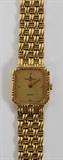 Lot# 26 BAUME & MERCIER, 18KT YELLOW GOLD LADY'S WATCH, "Baume & Mercier Quartz" on face; stamped "18kt 1487921 18487" on back of rectangular case; Band is 1/2" wide where it is attached to the watch itself and graduates ever so slightly near the clasp.