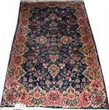 Lot# 46 KERMAN, WOOL IRANIAN RUG, 3' 11" X 6' 4", Featuring a dark blue ground with overall floral design with a wide stylized floral border.