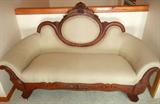 Lot# 150 ANTIQUE, AMERICAN MAHOGANY UPHOLSTERED SETTEE, H 39", L 67", D 27", Carved back, with oval back rest with leaf and nut design crest. Carved frame across front curving upwards at the ends to support armrests; bracket legs all supported on porcelain casters; Taupe with diamond design and dots.