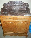 Lot# 157 FRENCH PROVINCIAL WASH STAND, H 42", L 32", D 20", having a Marble backsplash, with shelf; marble top; two half width drawers with moldings and brass pulls above two cabinet doors, also with moldings on facades, small button brass pulls. Contoured lower front skirt and carved feet.